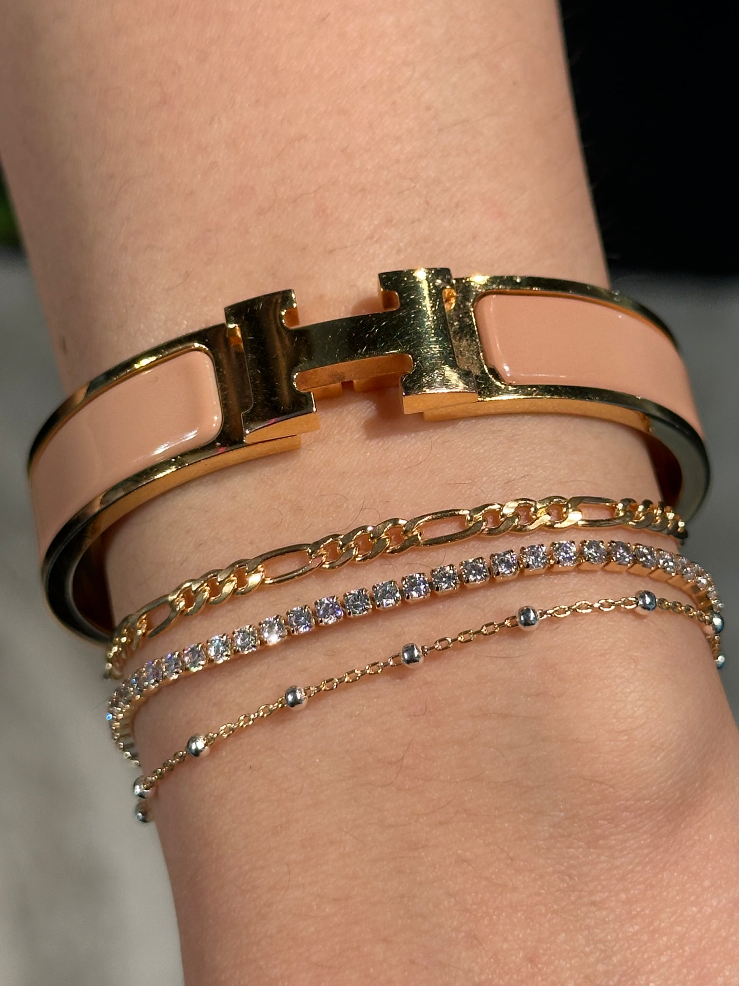 Gold permanent bracelet stack with Hermès Clic H bangle