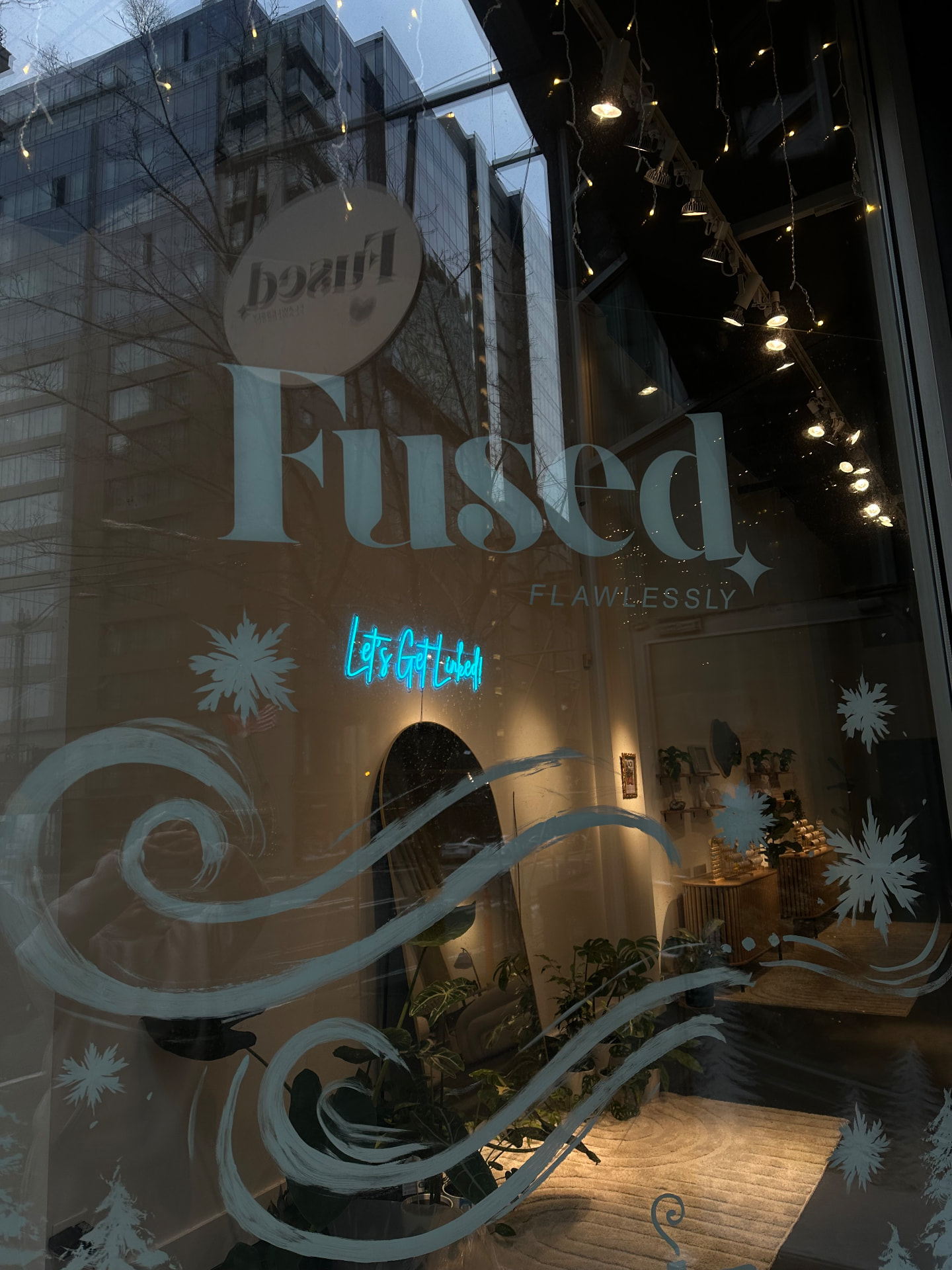 Flawlessly Fused window logo lit at dusk