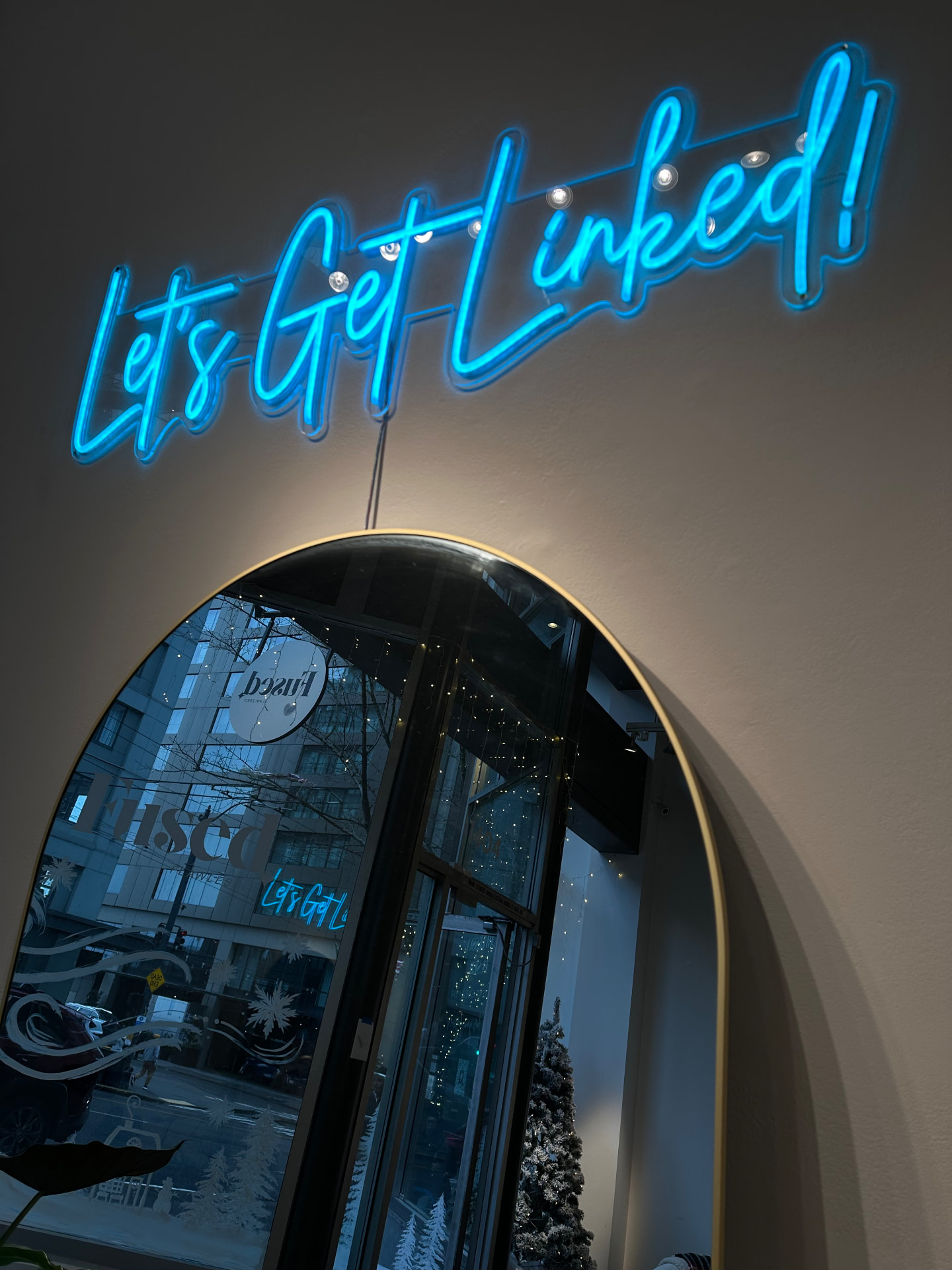 Let's Get Linked neon sign above the arched studio mirror